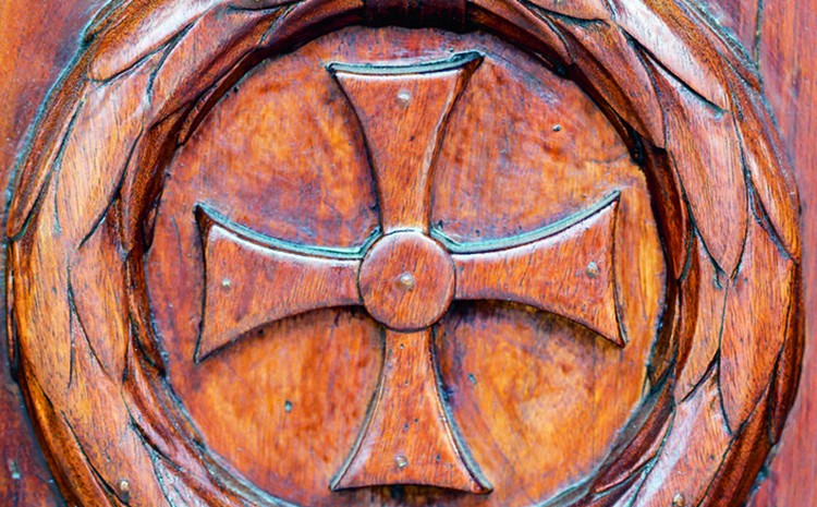 Croix sculptée sur la porte en bois de l'église Saint-Jean-Baptiste de Megève